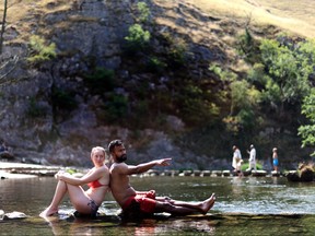 People sit in the River Dove in Dovedale during the heatwave, Derbyshire, Britain, July 19, 2022.