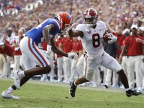 Alabama Crimson Tide wide receiver John Metchie III (8) runs with the ball as Florida Gators cornerback Avery Helm (24) defends during the second half at Ben Hill Griffin Stadium.