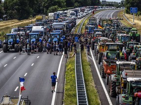 Farmers gather with their vehicles next to a Germany/Netherlands border sign during a protest on the A1 highway, near Rijssen, on June 29, 2022, against the Dutch Government's nitrogen plans. - Netherlands OUT (Photo by Vincent Jannink / ANP / AFP) / Netherlands OUT (Photo by VINCENT JANNINK/ANP/AFP via Getty Images)