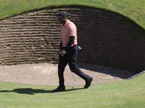 Tiger Woods walks by a pot bunker at St. Andrews.