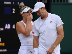 Gabriela Dabrowski and partner John Peers interact during their mixed doubles first round match against Ariel Behar and Demi Schuurs at at Wimbledon's All England Lawn Tennis and Croquet Club in London, Saturday, July 2, 2022.