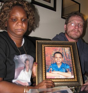Parents Lorna and Gerald Brown holding picture of Ephraim Brown, 11, who was killed during a shootout at his cousin’s brithday party in July.