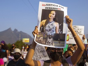 People hold signs as they participate in the women's march demanding justice for Debanhi Escobar, who disappeared on April 9 and was found dead yesterday in the water tank of the Nueva Castilla motel, in Monterrey, Nuevo Leon state, on April 22, 2022.