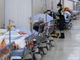 Paramedics transfer patients to the emergency room triage but have no choice but to leave them in the hallway due to an at capacity emergency room at the Humber River Hospital during the COVID-19 pandemic in Toronto on Tuesday, January 25, 2022. THE CANADIAN PRESS/Nathan Denette