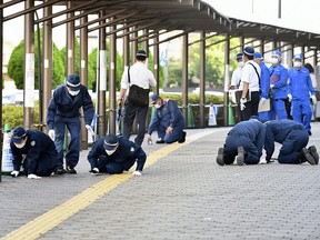 Investigators work at the scene of former Japanese Prime Minister Shinzo Abe's assassination, in Nara, Japan in this photo taken by Kyodo on July 13, 2022.