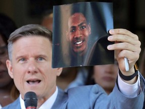 Attorney Bobby DiCello holds up a photograph of Jayland Walker, the man who was shot dead by Akron Police on June 25, as he speaks on behalf of the Walker family during a press conference at St. Ashworth Temple in Akron, Ohio, Thursday, June 30, 2022.