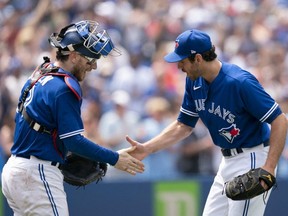 Blue Jays closer Jordan Romano (right) celebrates the win with catcher Danny Jansen (left) against the Royals at the end of the game at Rogers Centre in Toronto, Sunday, July 17, 2022.