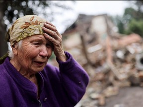 Raisa Shapoval, 83, cries in front of the site of a military strike in Chuhuiv, about 6 km from the frontline, amid Russia's invasion of Ukraine, in Kharkiv region, July 16, 2022.