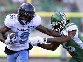 Toronto Argonauts receiver Kurleigh Gittens Jr. (left) tries to break the tackle of Saskatchewan Roughriders defensive back Mike Edem on Sunday at Mosaic Stadium. Gittens Jr. posted a career-high 152 yards and also had a touchdown.