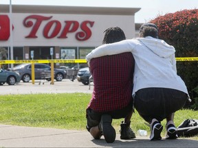 Mourners react while attending a vigil for victims of the shooting at a TOPS supermarket in Buffalo May 15, 2022. REUTERS/Brendan McDermid