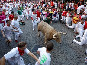 Revellers run during the running of the bulls at the San Fermin festival in Pamplona, Spain, July 7, 2022.