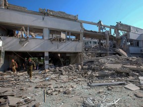 Police officers inspect a building of H.S. Skovoroda Kharkiv National Pedagogical University damaged by a Russian missile strike, as Russia's attack on Ukraine continues, in Kharkiv, Ukraine, Wednesday, July 6, 2022.