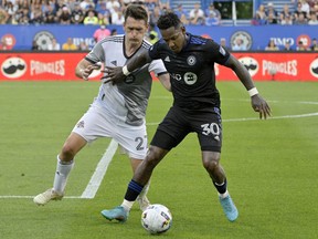 CF Montreal midfielder Romell Quioto (30) holds off Toronto FC defender Shane O'Neill during the first half at Stade Saputo on Saturday night.