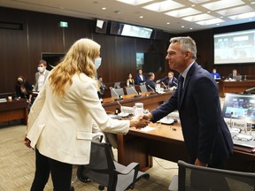 Witnesses Michel Ruest, , senior director of programs for Sport Canada, shakes hands with Pascale St-Onge, minister of sport, as they appear at the standing committee on Canadian Heritage in Ottawa on Tuesday, looking into Hockey Canada's involvement in alleged sexual assaults committed in 2018.