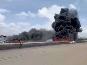 Smoke billows from a plane that flipped over after a crash landing, in Mogadishu, Somalia, July 18, 2022, in this screen grab obtained from a social media video obtained by Reuters.