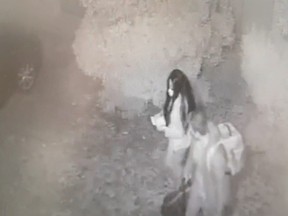 A man and a woman walk out from Restaurante Atrio, carrying three bags of stolen wine bottles worth up to 1.7 million euros, in Caceres, Spain, on Oct. 27, 2021 in this frame grab taken from CCTV video released on July 20, 2022.
