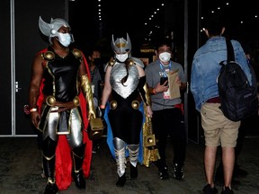 Cosplayers dressed as the Marvel Comics character Thor walk the convention floor at Comic-Con International in San Diego, Thursday, July 21, 2022.