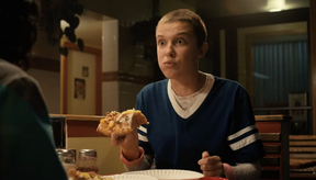 Eleven (Millie Bobby Brown) is amazed after biting into a piece of pineapple pizza on Stranger Things.