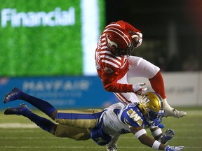 Calgary Stampeders William Langlais is tackled by Winnipeg Blue Bombers DeAundre Alford in CFL action at McMahon stadium in Calgary on Saturday, November 20, 2021.