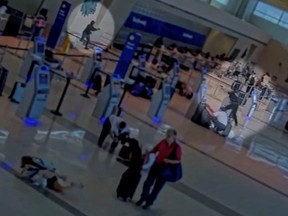 A woman identified by the Dallas Police Department as Portia Odufuwa holds a gun at Dallas Love Field Airport in Dallas, Texas, U.S. July 25, 2022 in this screen grab from a video released by Dallas Police Department on July 26, 2022.