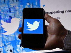 In this file photo illustration taken April 26, 2022, a phone screen displays the Twitter logo on a Twitter page background, in Washington, D.C.