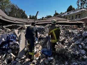 This handout photo taken and released by Ukrainian Emergency Service on Wednesday, July 27, 2022 shows rescuers clearing the rubble of a hotel building partially destroyed as a result of a missile strike to Bakhmut, Donetsk region, amid the Russian invasion of Ukraine.