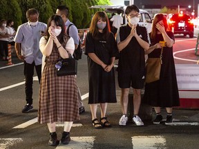 People pray and cry at a site outside of Yamato-Saidaiji Station where Japan’s former prime minister, Shinzo Abe, was shot during an election campaign on July 8, 2022 in Nara, Japan.