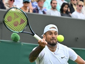 Australia's Nick Kyrgios returns the ball to Serbia's Filip Krajinovic during their men's singles tennis match on the fourth day of the 2022 Wimbledon Championships at The All England Tennis Club in Wimbledon, southwest London, on June 30, 2022.