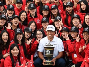 Hideki Matsuyama (C) of Japan poses with the winner's trophy after the final round of the World Golf Championships-HSBC Champions golf tournament in Shanghai on October 30, 2016.