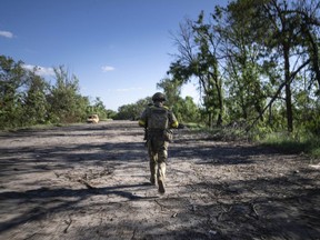 A Ukrainian soldier changes position on the frontline near Kharkiv, Ukraine, on Saturday, July 2, 2022.