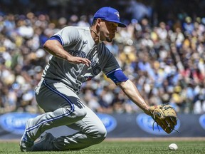 Toronto Blue Jays pitcher Jose Berrios (17) reaches for ball hit by Milwaukee Brewers third baseman Jace Peterson (not pictured) for a bunt single in the second inning at American Family Field.