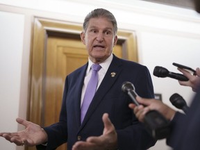 Sen. Joe Manchin, D-W.Va., is met by reporters outside the hearing room where he chairs the Senate Committee on Energy and Natural Resources, at the Capitol in Washington, July 21, 2022.