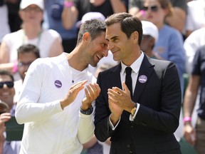 Serbia's Novak Djokovic and Switzerland's Roger Federer speak during a 100 years of Centre Court celebration on day seven of the Wimbledon tennis championships in London, Sunday, July 3, 2022.