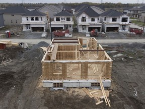 In this photo taken using a drone, homes under construction are seen in a new suburb, Friday, Oct. 15, 2021 in Ottawa.