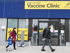 People walk past a vaccine clinic during the COVID-19 pandemic in Mississauga April 13, 2022.