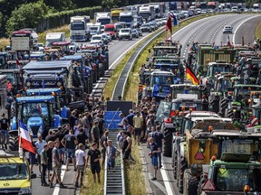 Farmers gather with their vehicles next to a Germany/Netherlands border sign during a protest on the A1 highway, near Rijssen, against the Dutch Government's nitrogen plans on June 29, 2022.
