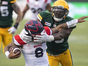 Montreal Alouettes quarterback Vernon Adams Jr.  (8) is tackled by Edmonton Elks' Kwaku Boateng (93) during second half CFL action in Edmonton, Alta., on Saturday August 14, 2021.