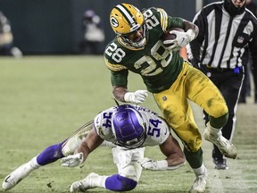 Jan 2, 2022; Green Bay, Wisconsin, USA; Green Bay Packers running back AJ Dillon (28) is pushed out of bounds by Minnesota Vikings linebacker Eric Kendricks (54) in the third quarter at Lambeau Field.