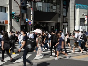 Pedestrians cross a road in Tokyo on Friday, July 8, 2022.