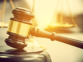 Legal office of lawyers, justice and law concept : Wooden judge gavel or a wood hammer and a soundboard used by a judge person on a desk in a courtroom with a blurred brass scale of justice behind.