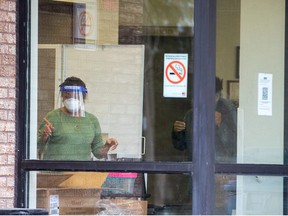 An employe screens a person entering Eatonville Care Centre after new provincial rules limiting visitations at long term care homes come into effect due to spiking coronavirus disease (COVID-19) case numbers in Toronto, Ontario, Canada December 30, 2021.