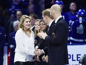 Canadian women's hockey star Hayley Wickenheiser, a member of the Hockey Hall of Fame's inductee class of 2019, is greeted by members of the Hall of Fame during a ceremony ahead of NHL hockey action between the Toronto Maple Leafs and Boston Bruins in Toronto on November 15, 2019. The Maple Leafs have promoted Wickenheiser, Ryan Hardy and Darryl Metcalf to the roles of assistant general manager and also hired Curtis Sanford as a goaltending coach.