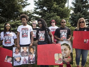 Anne Marie White, the mother of Jamal Francique, centre, poses for a photograph amongst her family and friends, during a community barbecue honouring the lives of D'Andre Campbell and Jamal Francique, two black men who were killed by police in 2020, among others, in Brampton, Ont., on August 23, 2020.