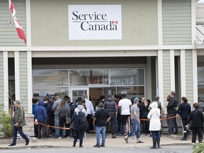 Travellers keen to get their passports in hand in time for take-off will now be able to request their mail-in applications be transferred to any of the more than 300 local Service Canada centres for processing. People line up at the passport office, Tuesday, June 21, 2022 in Laval, Que.