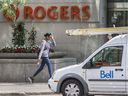 Ein Fußgänger geht am Montag, den 11. Juli 2022, am Spitznamen Rogers vorbei, mit einem Bell-Truck im Vordergrund. 