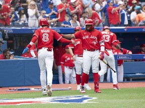 Toronto Blue Jays second baseman Cavan Biggio scores a run and celebrates with Toronto Blue Jays first baseman Vladimir Guerrero Jr. against the Tampa Bay Rays during the third inning at Rogers Centre on July 1, 2022.