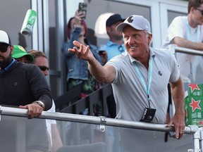 Greg Norman, CEO of LIV Golf, tosses a beer to spectators into the crowd surrounding the 18th green at the Portland Invitational LIV Golf tournament in North Plains, Ore., Saturday, July 2, 2022.