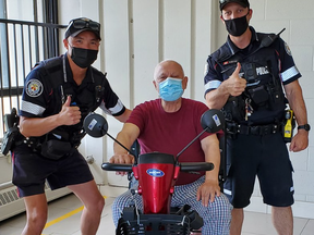 Toronto Police Consts. Scott Surridge and Gabriel Kuok help a senior out with a new scooter after his wheels were stolen.