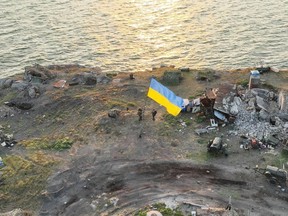 Ukrainian servicemen install a national flag on Snake Island, as Russia's attack on Ukraine continues, in the Odessa region of Ukraine in this photo released July 7, 2022.