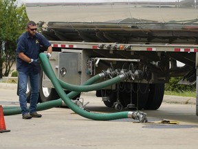 FILE - A gas tank driver adjusts his hose hookup to an underground tank on May 24, 2022, in Jackson, Miss. High diesel prices are driving up the cost of most goods, from groceries to Amazon orders and furniture, as nearly everything that is delivered, whether by truck, rail or ship, uses diesel fuel. Truckers are turning down hauling jobs in the states with the most expensive diesel.